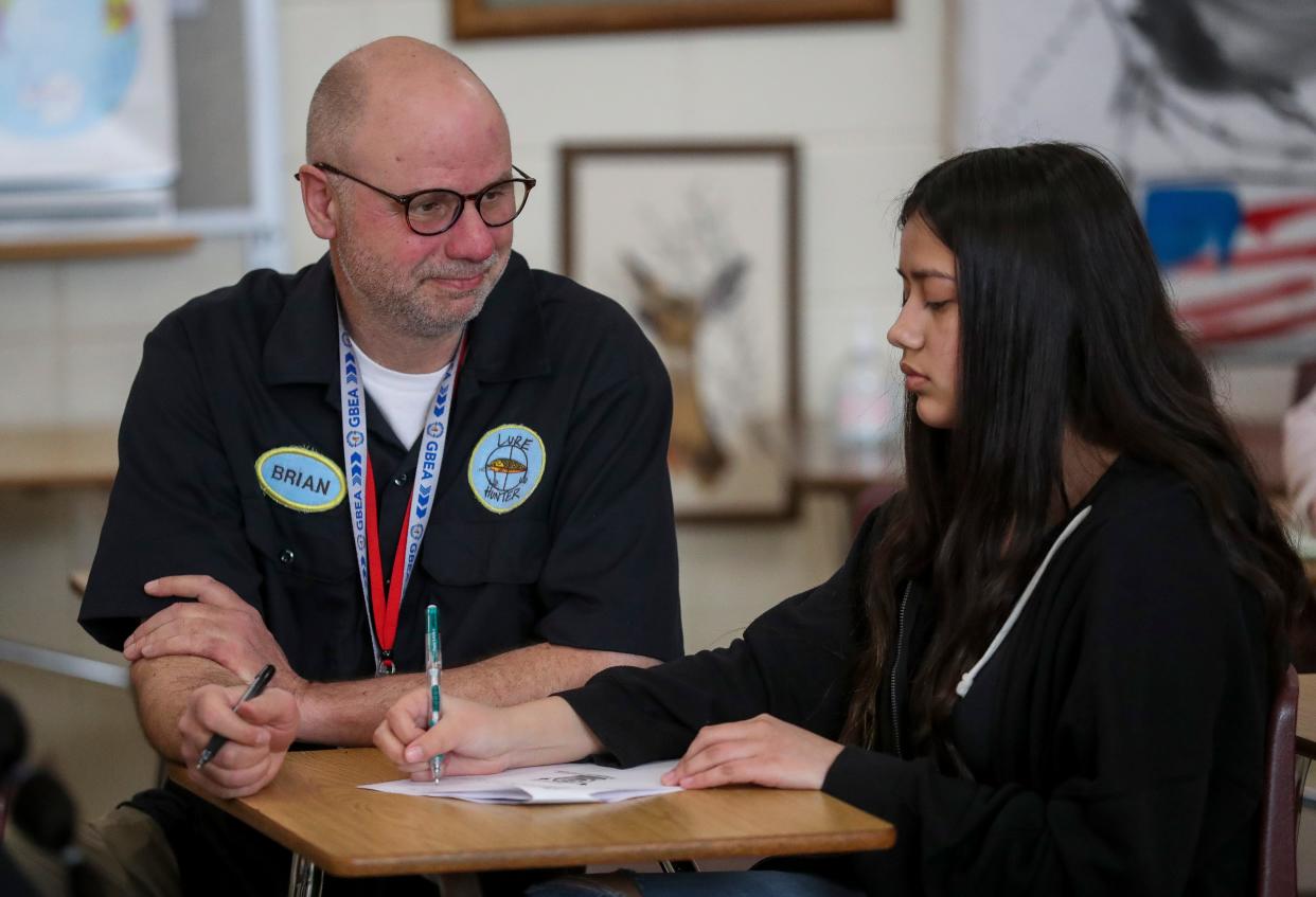 Teacher Brian Fisk helps student Brianna Bautista during class on April 9 at Green Bay East High School.