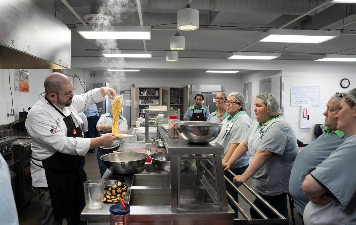Oct 24, 2023; Marysville, Ohio, USA; Chef and Instructor Justin Thatcher shows the consistency of the cooked pasta dough as students watch during a cooking class through Sinclair Community College at the Marysville Womens Reformatory.