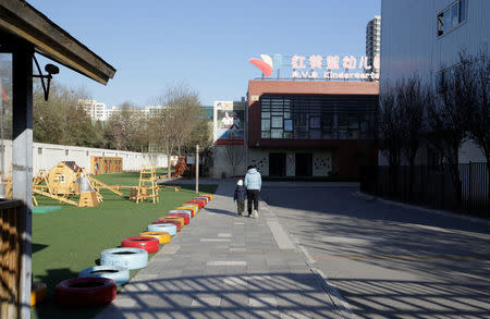 A child walks with a parent at the kindergarten run by pre-school operator RYB Education Inc being investigated by China's police, in Beijing, China November 24, 2017. REUTERS/Jason Lee