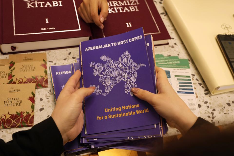 Pamphlets that read Azerbaijan to host COP29 are held at the Azerbaijan Pavilion during the COP28 U.N. Climate Summit, Friday, Dec. 8, 2023, in Dubai, United Arab Emirates. (AP Photo/Rafiq Maqbool)