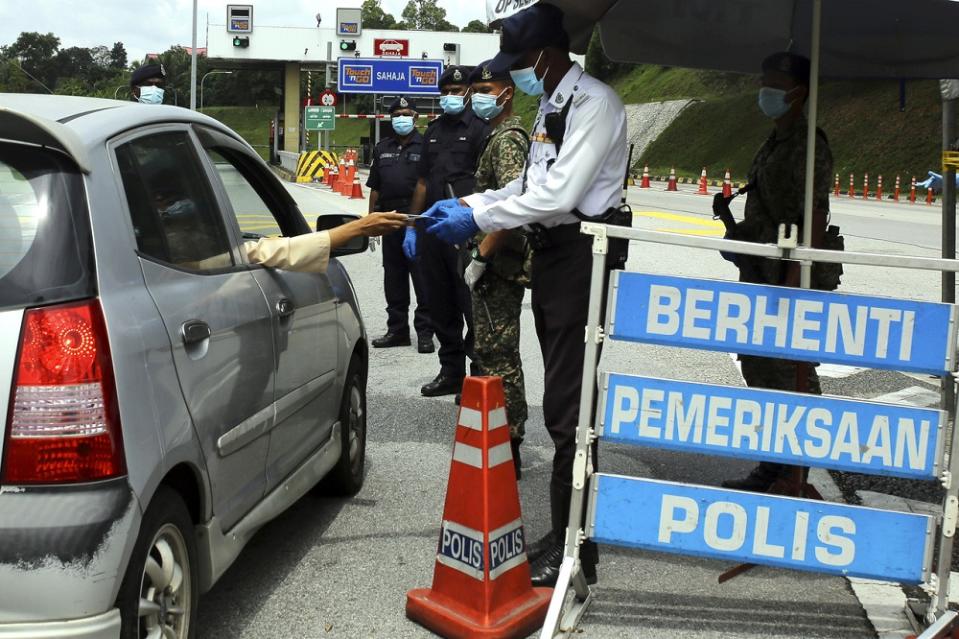 Policemen are seen at a roadblock located at the Seremban Toll Plaza during the first day of Hari Raya Aidilfitri in Seremban May 24, 2020. — Bernama pic