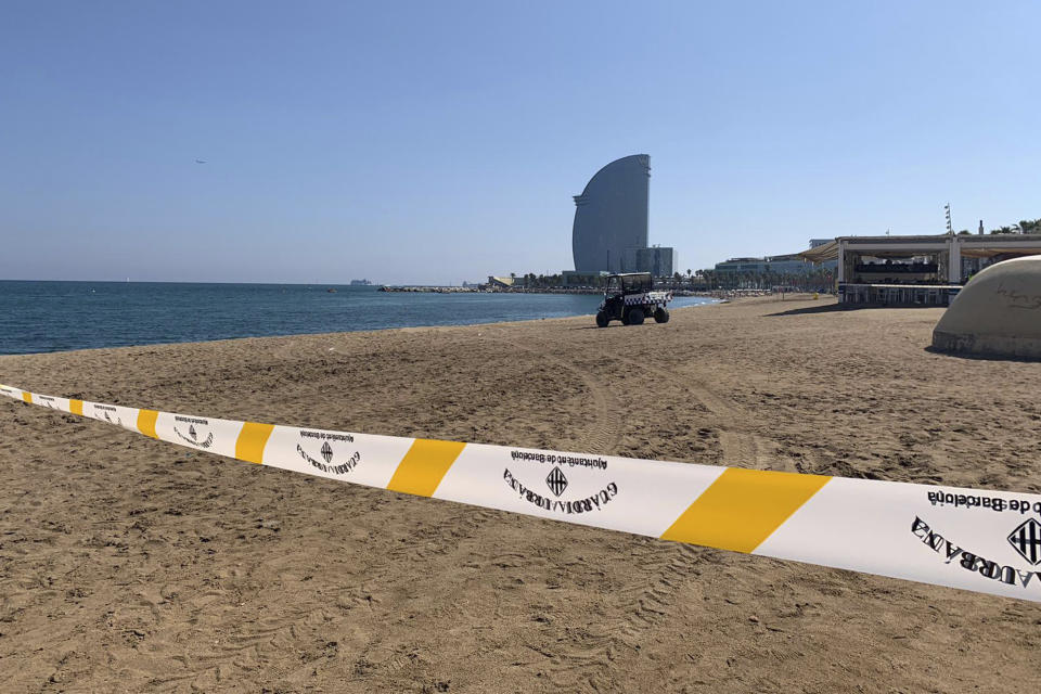 A police vehicle drives on a closed- off part of a beach in Barcelona, Spain, Sunday Aug. 25, 2019. Authorities in Barcelona have evacuated one of the Spanish city's popular beaches after reports of a possible explosive device there, though reports indicated it was an old, possibly wartime device and was underwater off the coast. (AP Photo/Ignacio Murillo)