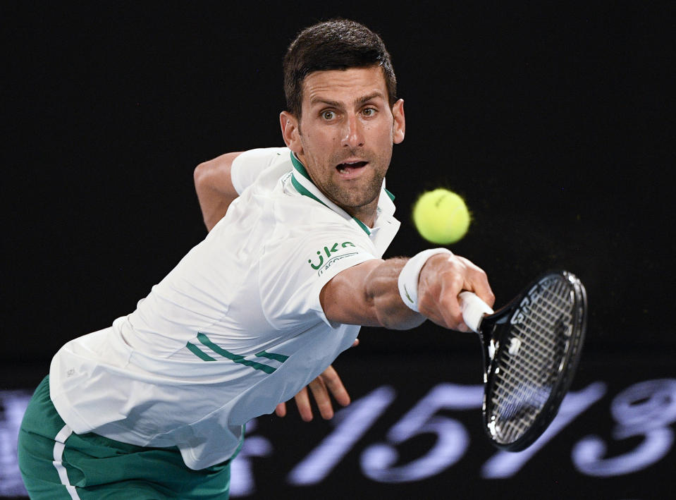 Serbia's Novak Djokovic hits a backhand return to Russia's Aslan Karatsev during their semifinal match at the Australian Open tennis championship in Melbourne, Australia, Thursday, Feb. 18, 2021.(AP Photo/Andy Brownbill)