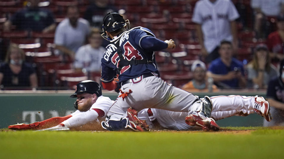 Boston Red Sox's Alex Verdugo beats the tag by Atlanta Braves catcher William Contreras (24) to score on a single by Xander Bogaerts during the sixth inning of a baseball game at Fenway Park, Wednesday, May 26, 2021, in Boston. (AP Photo/Charles Krupa)
