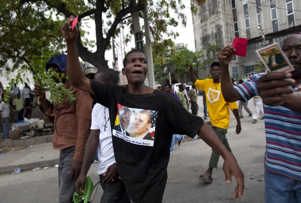 A demonstrator wears a T-shirt with an image of President Barack Obama, right, and Ghana's President John Atta Mills during a protest against Haiti's President Michel Martelly government in Port-au-Prince, Haiti, Sunday, Sept. 30, 2012. (AP Photo/Dieu Nalio Chery)