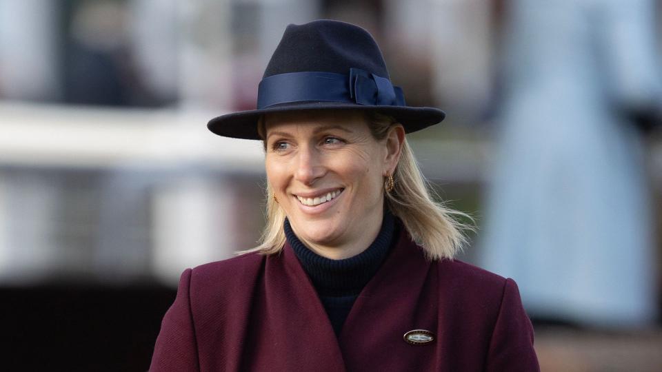 Zara Tindall walking in a maroon coat