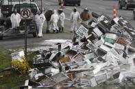 Beekeepers attend to a semi-trailer truck that overturned with a cargo of bees on a highway in Lynnwood, Washington April 17, 2015. A truck carrying millions of honey bees overturned on a freeway north of Seattle on Friday, creating a massive traffic jam as the swarming insects stung firefighters, officials said. (REUTERS/Ian Terry)