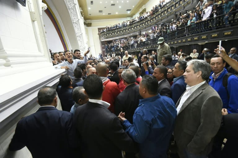 Members of the National Assembly react as supporters of Venezuelan President Nicolas Maduro force their way into an extraordinary session called by opposition leaders, in Caracas on October 23, 2016