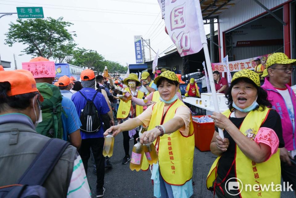 白沙屯媽祖的信眾在彰化花壇中山路上遞水給香燈腳們。   圖：張良一/攝