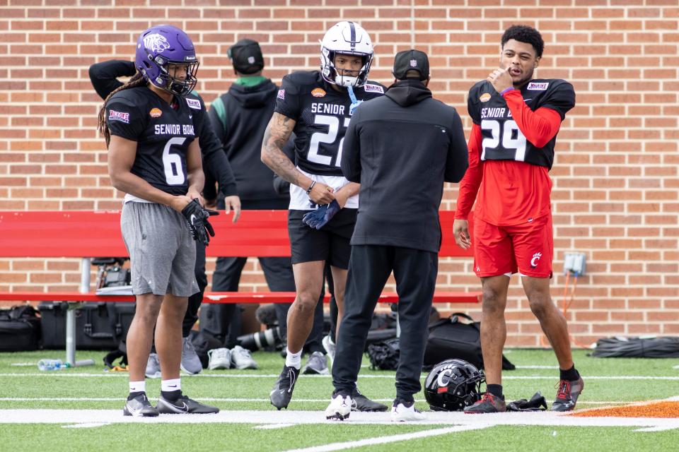 Feb 1, 2022; Mobile, AL, USA; National defensive back Gregory Junior of Ouachita Baptist (6) and National defensive back Tariq Castro-Fields of Penn State (22) and National defensive back Coby Bryant of Cincinnati (29) talks with an assistant coach before National practice for the 2022 Senior Bowl at Hancock Whitney Stadium. Mandatory Credit: Vasha Hunt-USA TODAY Sports