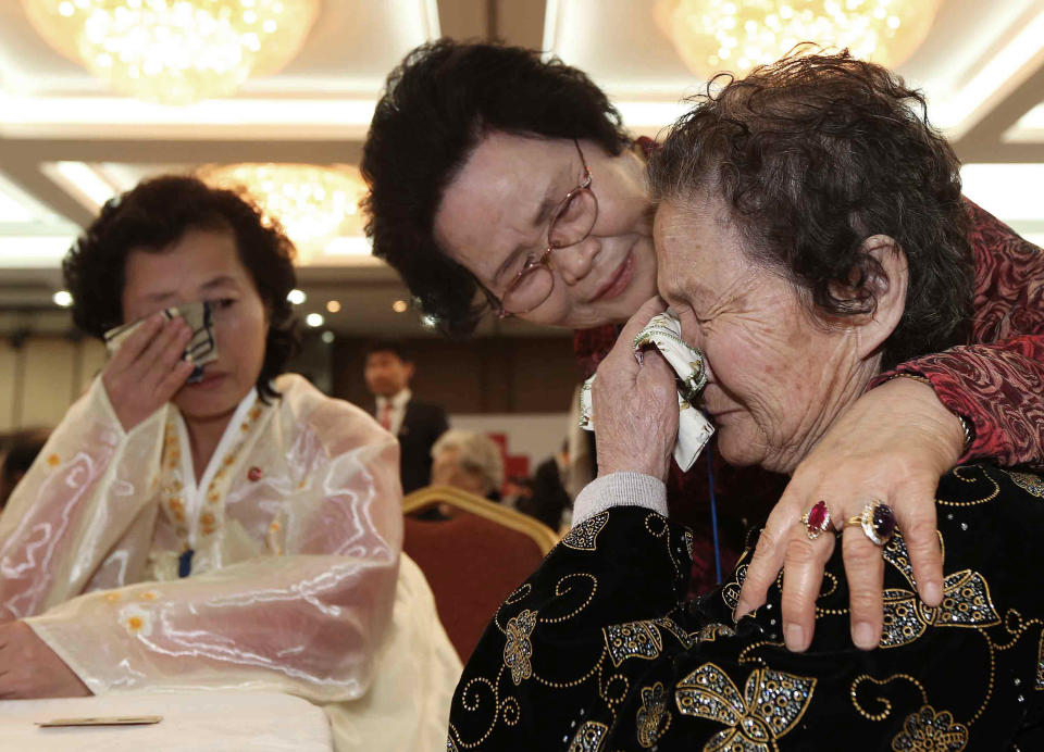 North Korean Kim Tae Un, right, weeps as she meets with her South Korean sister Kim Sa-bun, center, during the Separated Family Reunion Meeting at Diamond Mountain resort in North Korea, Sunday, Feb. 23, 2014. Elderly North and South Koreans separated for six decades are tearfully reuniting, grateful to embrace children, brothers, sisters and spouses they had thought they might never see again. (AP Photo/Yonhap, Lee Ji-eun) KOREA OUT