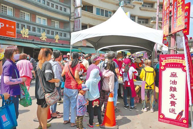 雲林縣「北港國際糕餅麻油節」22日在北港朝天宮前廣場登場，民眾大排長龍享用免費麻油雞。（張朝欣攝）