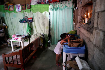 Jellyset, daughter of the late Bernabe Sabangan, is pictured in front of a shrine for her father in Barangay Bagong Silangan in Quezon City, Metro Manila, Philippines November 28, 2017. REUTERS/Erik De Castro/Files