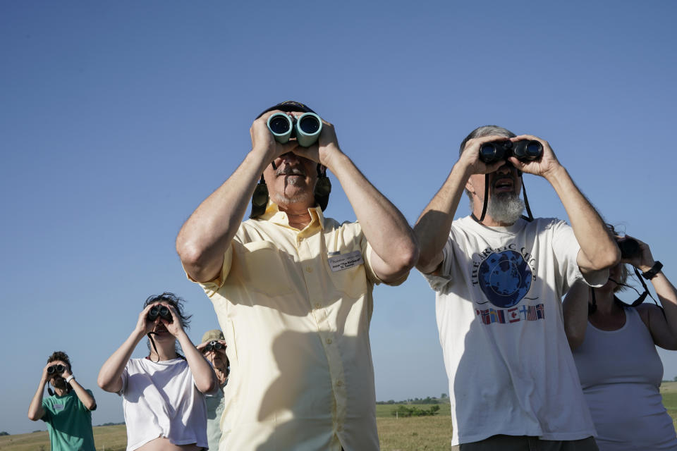 Jason St. Sauver, center, senior manager for education at Spring Creek Prairie Audubon Center, looks through binoculars while leading a grassland bird tour, Tuesday, June 20, 2023, in Denton, Neb. North America's grassland birds are deeply in trouble 50 years after adoption of the Endangered Species Act, with numbers plunging as habitat loss, land degradation and climate change threaten what remains of a once-vast ecosystem. (AP Photo/Joshua A. Bickel)