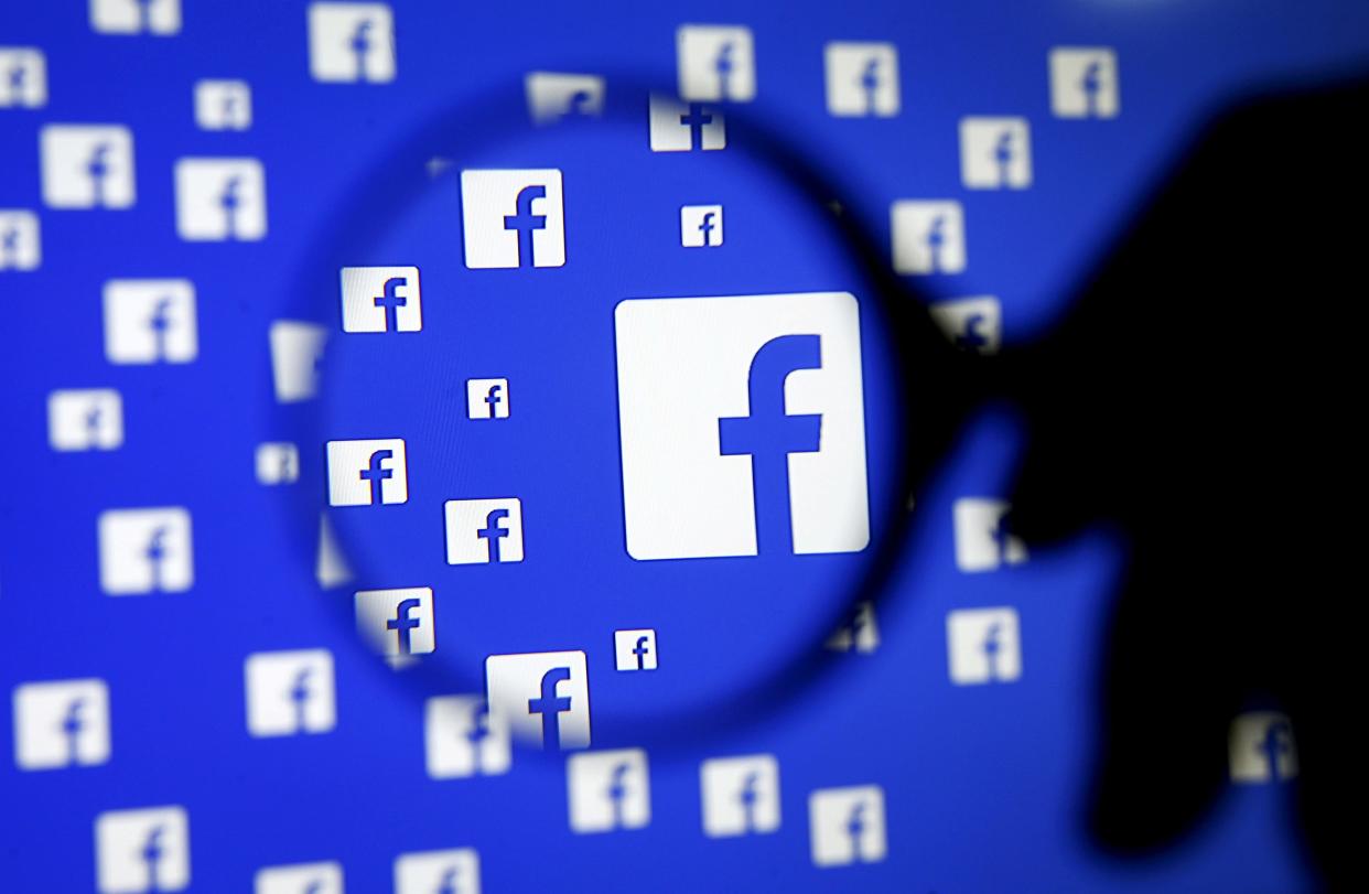 FILE PHOTO: A man poses with a magnifier in front of a Facebook logo on display in this illustration taken in Sarajevo, Bosnia and Herzegovina, December 16, 2015.   REUTERS/Dado Ruvic/Illustration