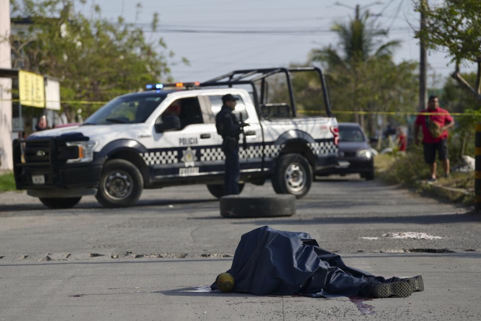 El cadáver de un policía estatal de Veracruz yace en el medio de una carretera tras ser abatido mientras patrullaba en el vecindario de Lomas de Río Medio, en Veracruz, México, el 12 de marzo de 2024. (AP Foto/Félix Márquez)