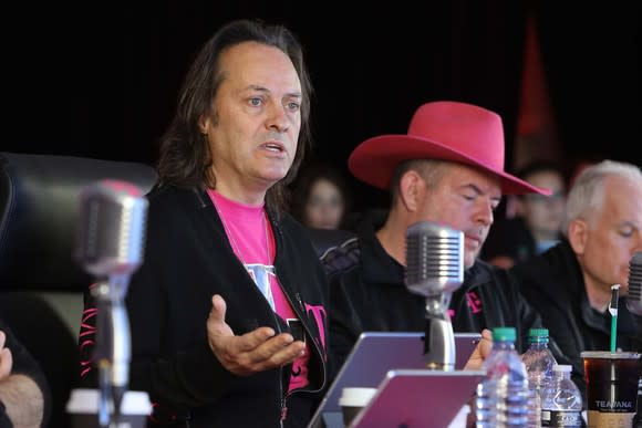 T-Mobile's management sitting in front of microphones.