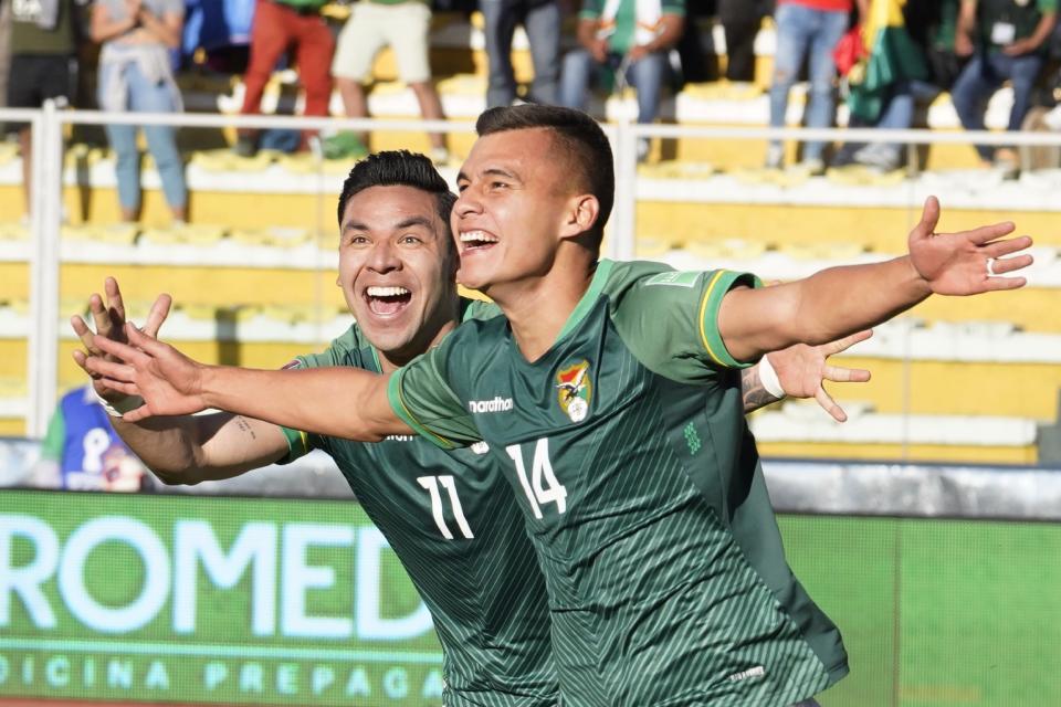 Bolivia's Moises Villaroel, right, celebrates with his teammate Carmelo Algarañaz after scoring his side´s second goal against Paraguay during a qualifying soccer match for the FIFA World Cup Qatar 2022, at Hernando Siles stadium in La Paz, Bolivia, Thursday, Oct. 14, 2021. (Javier Mamani/Pool via AP)