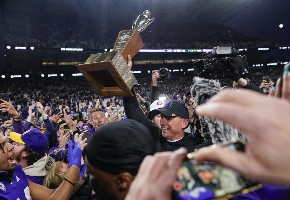 Washington head coach Kalen DeBoer holds up the Apple Cup trophy after a 24-21 win over Washington State in an NCAA college football game, Saturday, Nov. 25, 2023, in Seattle. (AP Photo/Lindsey Wasson)