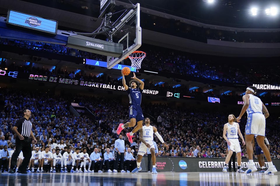 St. Peter's Daryl Banks III (5) goes up for a shot against North Carolina's Caleb Love (2) during the first half of a college basketball game in the Elite 8 round of the NCAA tournament, Sunday, March 27, 2022, in Philadelphia. (AP Photo/Matt Rourke)