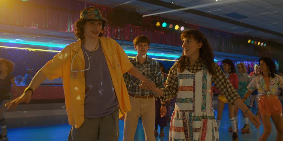 Finn Wolfhard, Noah Schnapp and Millie Bobby Brown roller skating in “Stranger Things” season 4, which debuted in late May. - Credit: ©Netflix/Courtesy Everett Collection