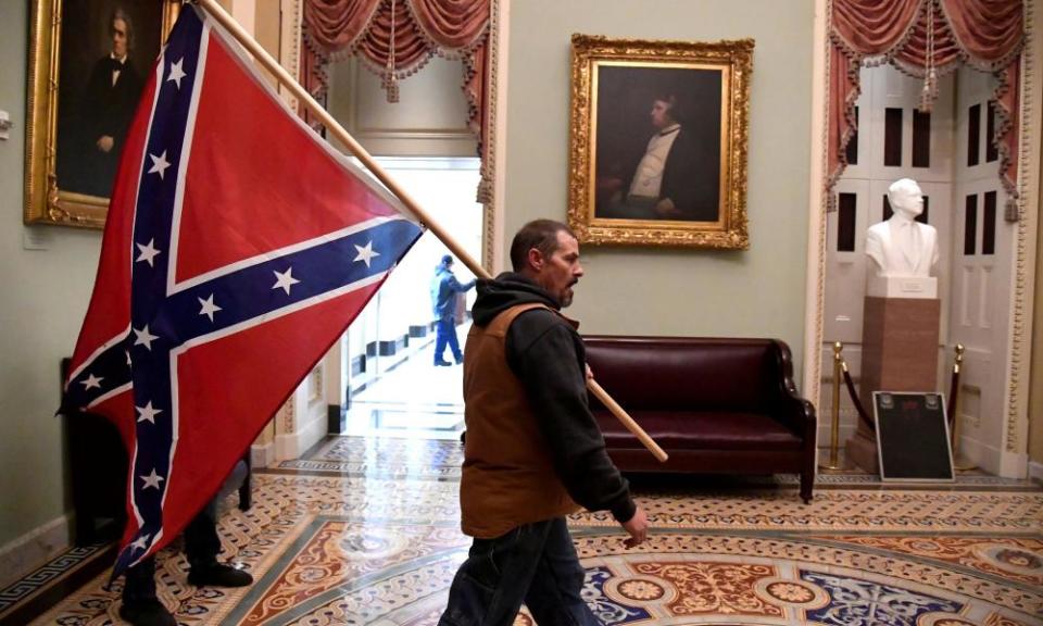 A man carries a Confederate battle flag on the second floor of the US Capitol.