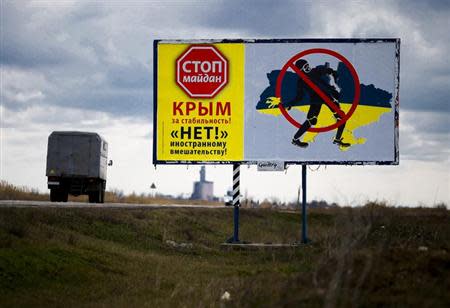 A lorry drives past a billboard denouncing Kiev's "Maidan" movement at a highway near the Crimean city of Simferopol March 5, 2014. REUTERS/Thomas Peter