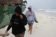 Tourists walk on the beach as the tail end of Hurricane Zeta makes landfall in Playa del Carmen, Mexico, early Tuesday, Oct. 27, 2020. Zeta is leaving Mexico’s Yucatan Peninsula on a path that could hit New Orleans Wednesday night. (AP Photo/Tomas Stargardter)