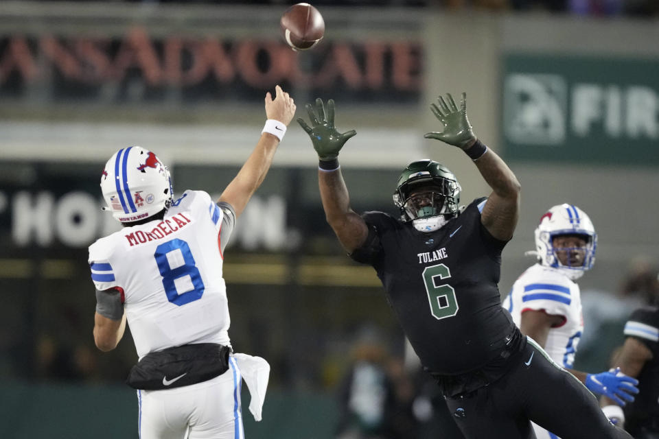 Southern Methodist quarterback Tanner Mordecai (8) passes under pressure from Tulane linebacker Darius Hodges (6) during the first half of an NCAA college football game in New Orleans, Thursday, Nov. 17, 2022. (AP Photo/Gerald Herbert)