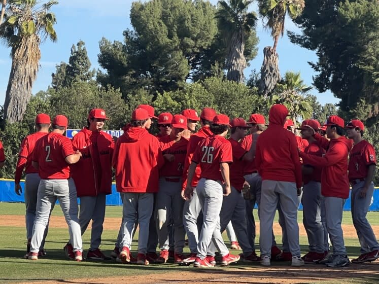 Harvard-Westlake players congratulate pitcher Avery Thau after his shutout over La Mirada 9-0.