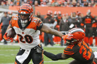 Cincinnati Bengals running back Joe Mixon (28) rushes against Cleveland Browns cornerback Denzel Ward (21) during the second half of an NFL football game, Sunday, Dec. 8, 2019, in Cleveland. (AP Photo/Ron Schwane)