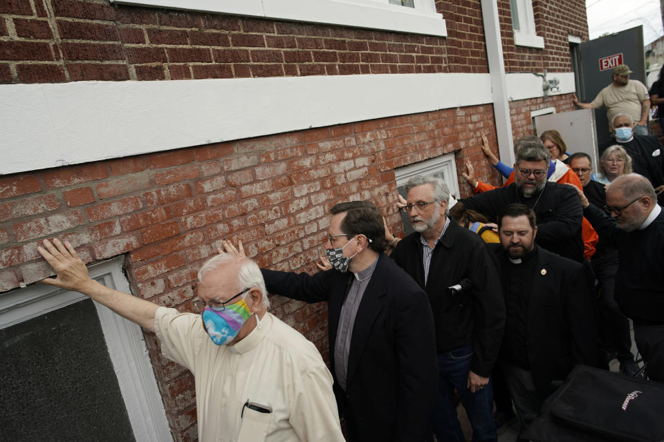 Clergy and religious leaders hold their hands on a prayer wall outside of the historic Vernon African Methodist Episcopal Church in the Greenwood neighborhood during the centennial of the Tulsa Race Massacre, Monday, May 31, 2021, in Tulsa, Okla. The church was largely destroyed when a white mob descended on the prosperous Black neighborhood in 1921, burning, killing, looting and leveling a 35-square-block area. (AP Photo/John Locher)