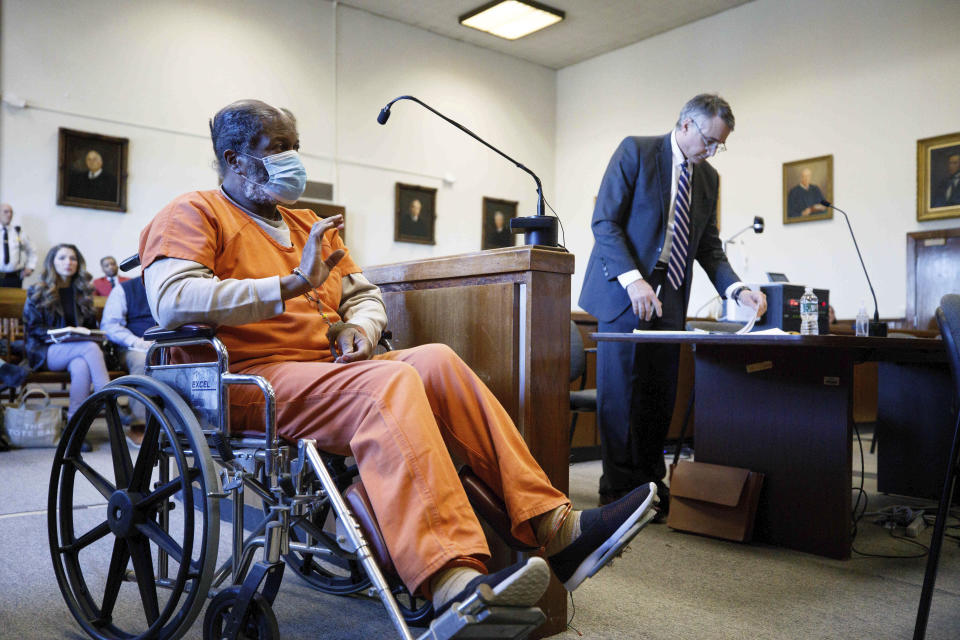 Ex-Olympian Conrad Mainwaring raises his shackled right hand as he is sworn-in at Berkshire Superior Court, Thursday, Feb. 8, 2024 in Pittsfield, Mass. Mainwaring, a former Olympian and longtime track coach pleaded guilty Thursday to charges of sexually molesting young boys while working at a sports camp in western Massachusetts in the 1970s.(Stephanie Zollshan/The Berkshire Eagle via AP)