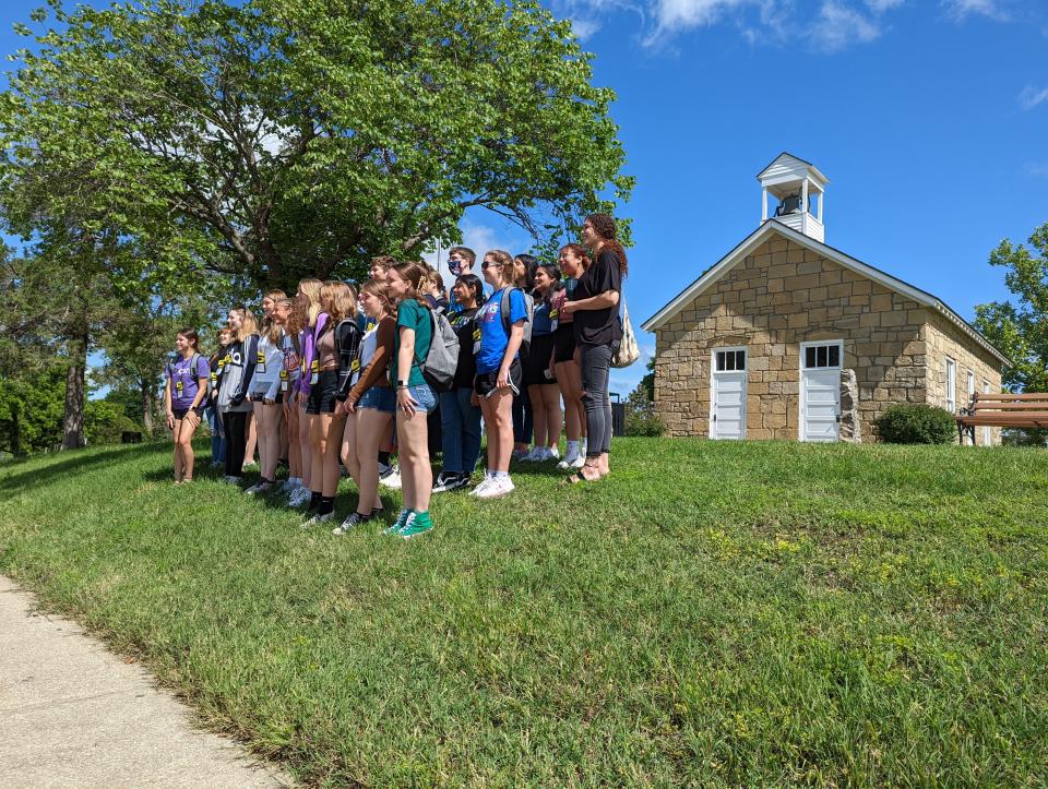 The 60 campers at the Kansas Future Teacher Academy pose in front of the one-room schoolhouse on the north end of Emporia State University's campus.