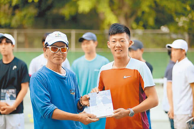 曾育欣（右）贈送前輩盧彥勳傳記給教練陳南與新興國中網球隊學弟。（李弘斌攝）