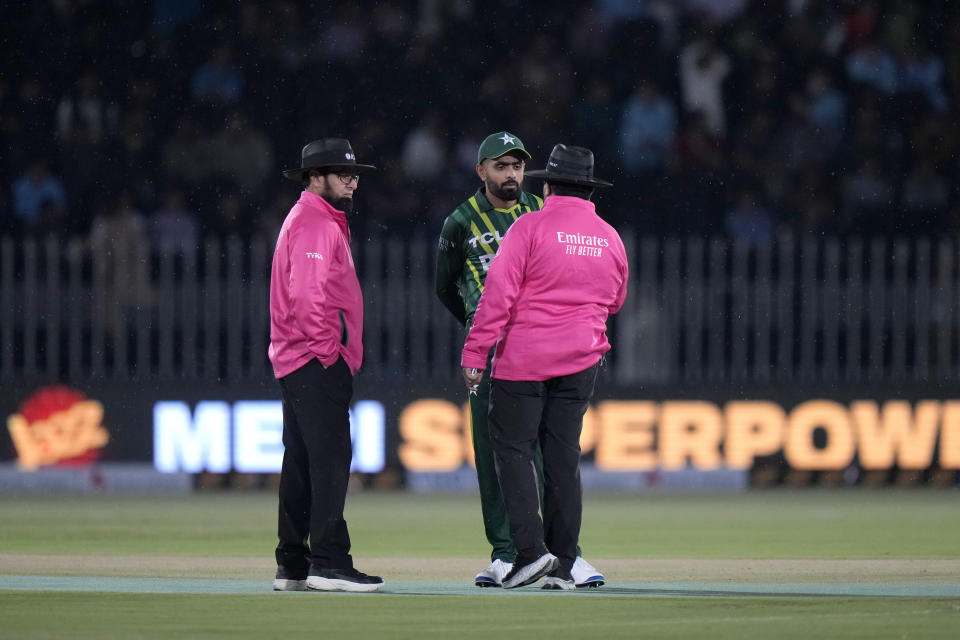 Pakistan's skipper Babar Azam, center, chats with umpires as rain stop the play of first T20 cricket match between Pakistan and New Zealand, in Rawalpindi, Pakistan, Thursday, April 18, 2024. (AP Photo/Anjum Naveed)