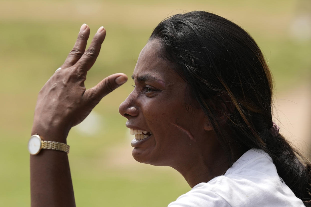 A Sri Lankan woman cries after anti-government protesters were attacked by government supporters outside president's office in Colombo, Sri Lanka, Monday, May 9, 2022. Government supporters on Monday attacked protesters who have been camped outside the offices of Sri Lanka's president and prime minster, as trade unions began a “Week of Protests” demanding the government change and its president to step down over the country’s worst economic crisis in memory. (AP Photo/Eranga Jayawardena)