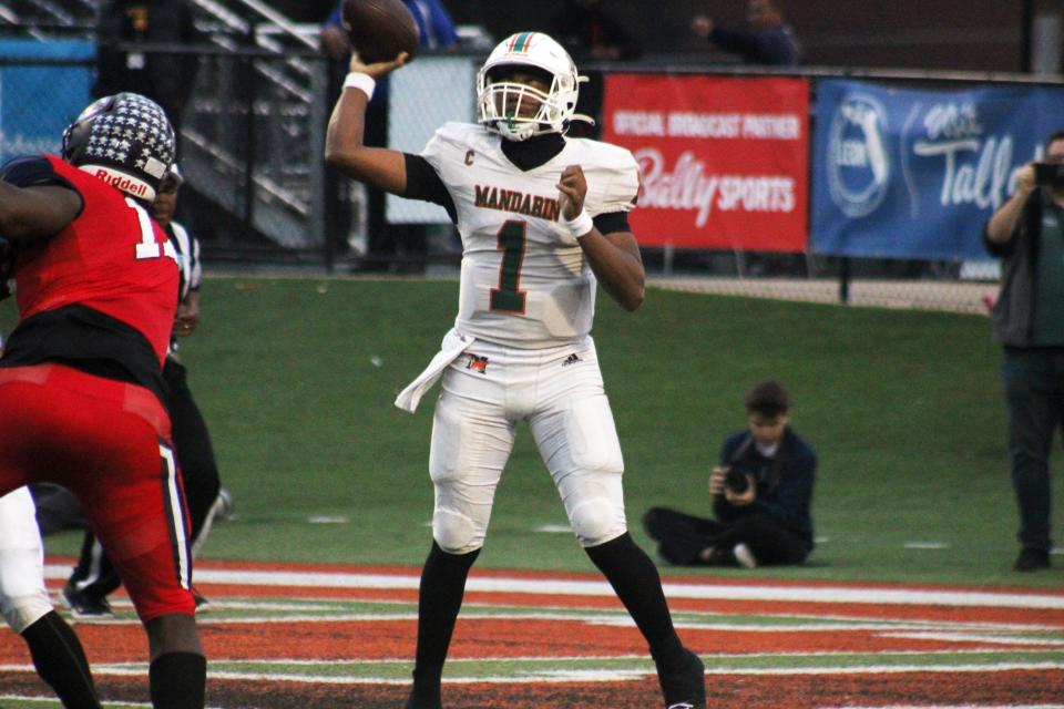 Mandarin quarterback Tramell Jones (1) prepares to toss a short pass over Miami Columbus pass rusher Willis McGahee IV (17) during the FHSAA Class 4M high school football championship game on December 8, 2023. [Clayton Freeman/Florida Times-Union]