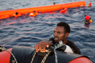 <p>A migrant from Eritrea grabs a RIB after jumping into the water from a crowded wooden boat during a rescue operation at the Mediterranean sea, about 13 miles north of Sabratha, Libya, Monday, Aug. 29, 2016. (AP Photo/Emilio Morenatti) </p>