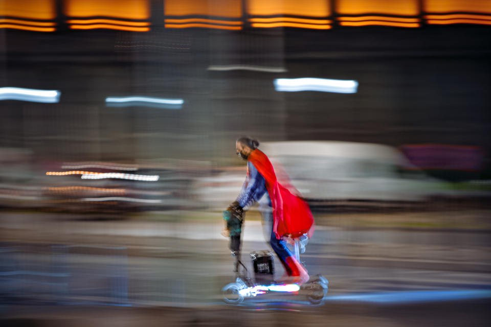 A man wearing a superhero costume rides a scooter in Bucharest, Romania, Friday, Oct. 23, 2020. In much of Europe, city squares and streets, be they wide, elegant boulevards like in Paris or cobblestoned alleys in Rome, serve as animated evening extensions of drawing rooms and living rooms. As Coronavirus restrictions once again put limitations on how we live and socialize, AP photographers across Europe delivered a snapshot of how Friday evening, the gateway to the weekend, looks and feels. (AP Photo/Vadim Ghirda)