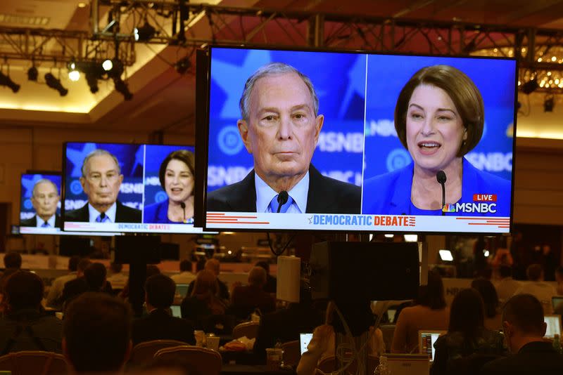 Former New York City Mayor Mike Bloomberg and Senator Amy Klobuchar are seen on live video monitors in the media filing center during the ninth Democratic 2020 U.S. Presidential candidates debate at the Paris Theater in Las Vegas