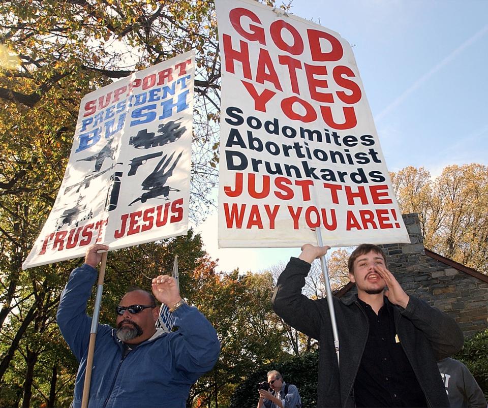 FILE - In this Oct. 25, 2003 file photo, Ruben Israel, left, of Los Angeles, and Stephen James, right, of Somerset, Penn., heckle anti-war demonstrators as they march in Washington to protest the U.S. troops presence in Iraq. Israel, who has crossed the country for 30 years to denounce behavior he considers sinful at venues including Mardi Gras and the newer Southern Decadence festival says followers arrested during this year’s Decadence will challenge a city ordinance that forbids preaching after dark on Bourbon Street. (AP Photo/Gerald Herbert, File)