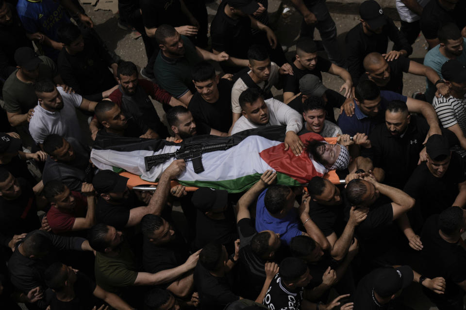 Mourners carry the body of Palestinian militant Fathi Rizk, 30, during his funeral in the Balata refugee camp near the West Bank town of Nablus Monday, May 22, 2023. The Israeli military raided the camp early Monday, sparking a firefight that killed Rizk and two other Palestinian militants. (AP Photo/Majdi Mohammed)