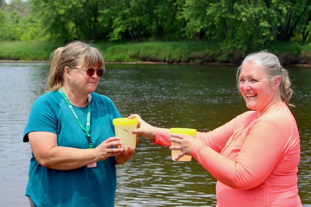 Michelle Bartsch (left), a research biologist at the U.S. Geological Survey's Upper Midwest Environmental Sciences Center, and Megan Bradley, a mussel biologist for the U.S. Fish and Wildlife Service, hold containers of juvenile winged mapleleaf mussels that they would later deposit into the Chippewa River in Meridean June 23.