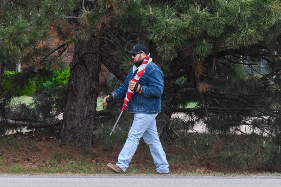 Judd Blevins walks with a rolled-up flag. (Michael Noble Jr. for NBC News)