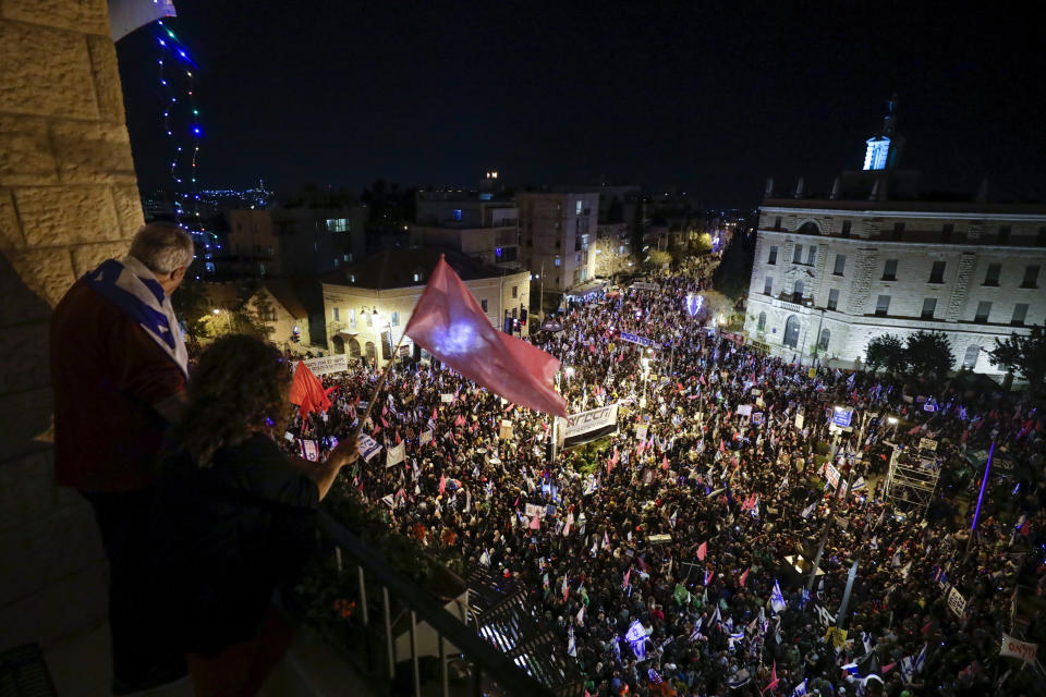 Thousands of protesters chant slogans and hold signs during a protest against Israel's Prime Minister Benjamin Netanyahu outside his residence in Jerusalem, Saturday, March. 20, 2021. The weekly protests against Netanyahu's corruption charges and his handling of the pandemic have persisted since summer, but tonight's gathering is the last before Israel will be holding its fourth election in two years on March 23. (AP Photo/Sebastian Scheiner)