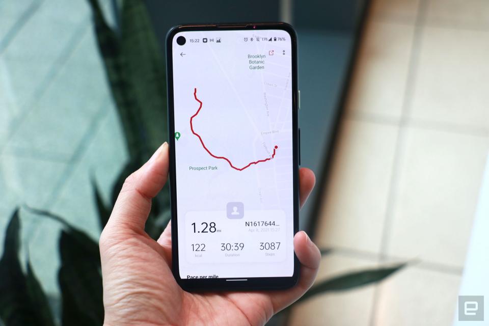 <p>OnePlus Watch review photos.  A hand holding up a Pixel phone with the OnePlus Health app showing a mapped walk. A redline marks a route and the map indicates nearby landmarks like Prospect Park and Brooklyn Botanic Gardens. At the bottom of the screen are metrics like distance (1.28 miles), calories burned (122), duration (30:39) and steps taken (3087).</p>
