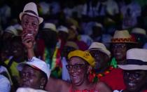 A supporter carries a mask of presidential candidate Domingos Simoes Pereira during his campaign rally in Bissau