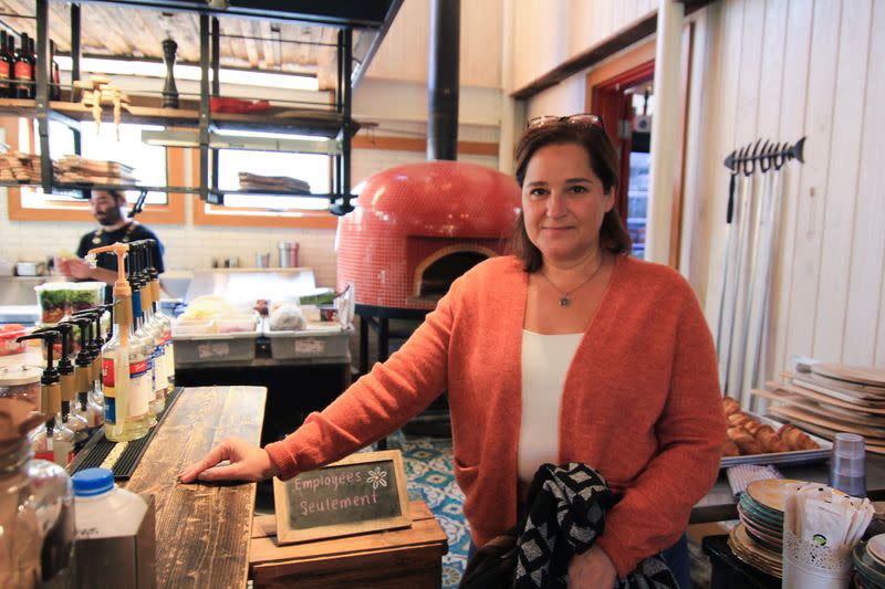 Manuela Teixeira stands at the counter of her cafe Biscotti & Cie, which she says faces a dire labor shortage, in Old Chelsea