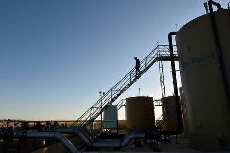 Carlos Riojas descends from storage tanks at a wastewater injection facility operated by On Point Energy in Big Spring, Texas U.S. February 12, 2019. Picture taken February 12, 2019. REUTERS/Nick Oxford